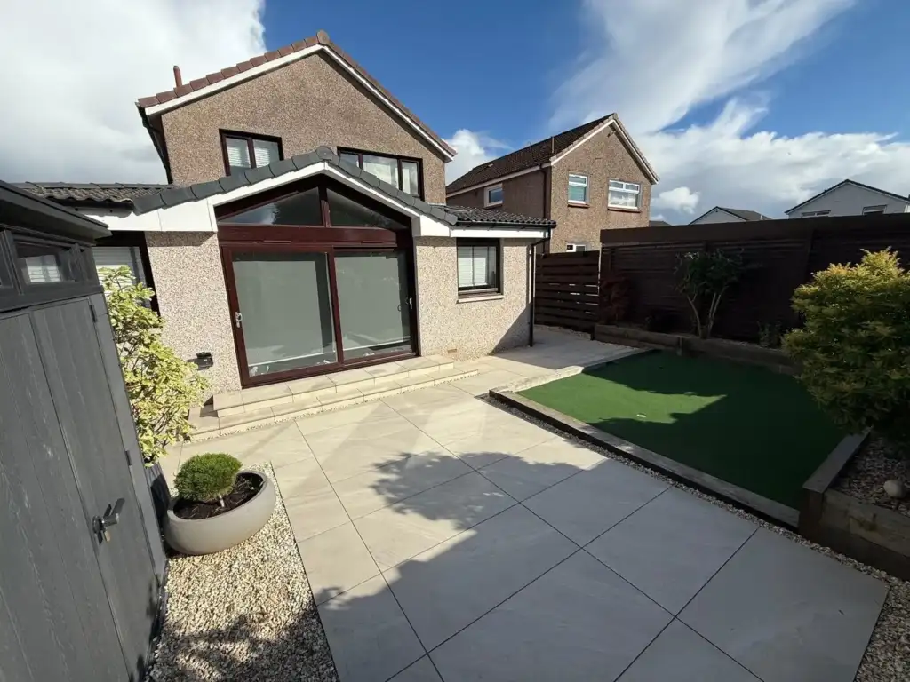 Completed Indie Paving garden with a paved patio, lawn and raised planting beds
