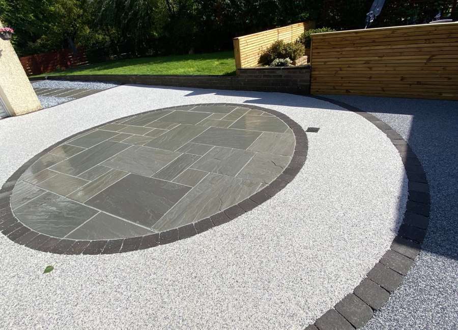 East Kilbride garden by Indie Paving with contrasting resin, circular paved patio and timber fencing