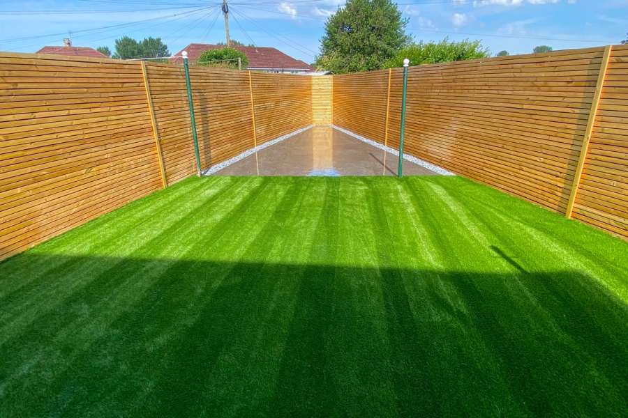 Springboig garden by Indie Paving with artificial grass, grey porcelain paving and Venetian-style timber fencing